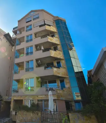 a tall building with an umbrella in front of it at Apartment Golden Lavender in Budva