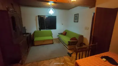a living room with two green chairs and a table at Holiday house Nebojsa in Bar