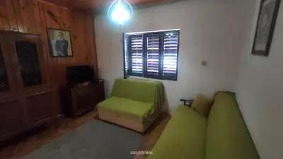 a living room with a green couch and a chair at Holiday house Nebojsa in Bar