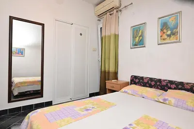 a bedroom with a bed and a mirror at Apartments Holiday in Budva