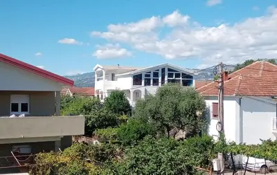 a view of a white house with trees and buildings at Hostel Olea in Podgorica