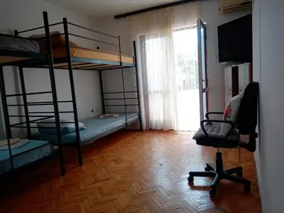 a room with three bunk beds and a chair at Hostel Olea in Podgorica