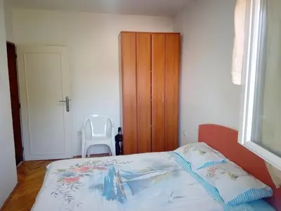a bedroom with a bed and a wooden cabinet at Hostel Olea in Podgorica