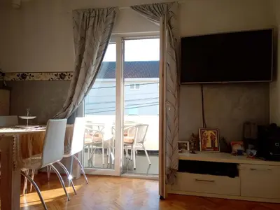 a living room with a sliding glass door to a patio at Hostel Olea in Podgorica