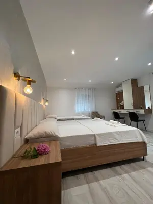 a bedroom with a large bed and a table with flowers at Apartments Hillside in Ulcinj