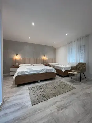 a large bedroom with two beds and a chair at Apartments Hillside in Ulcinj