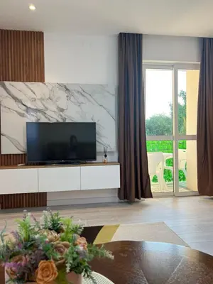 a living room with a flat screen tv on a white cabinet at Apartments Hillside in Ulcinj