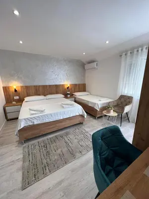 a hotel room with two beds and a couch at Apartments Hillside in Ulcinj