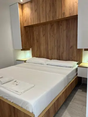 a bed in a room with a wooden wall at Apartments Hillside in Ulcinj