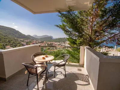 a balcony with a table and chairs and a view at Mum's Apartment in Petrovac na Moru