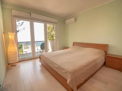 a bedroom with a bed and a large window at Mum's Apartment in Petrovac na Moru