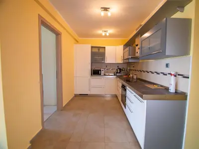 a kitchen with white appliances and yellow walls at Mum's Apartment in Petrovac na Moru