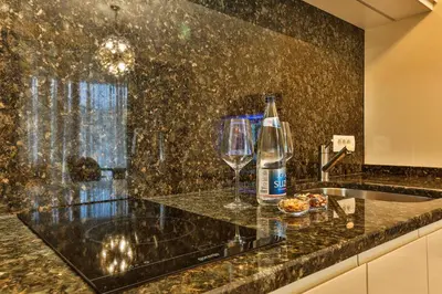 a kitchen counter with a bottle of water and a wine glass at Royal Montesun Apartments in Budva