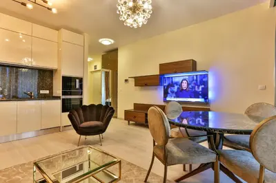 a living room with a table and chairs and a tv at Royal Montesun Apartments in Budva