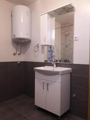 a bathroom with a white sink and a mirror at Pensions Airport in Podgorica