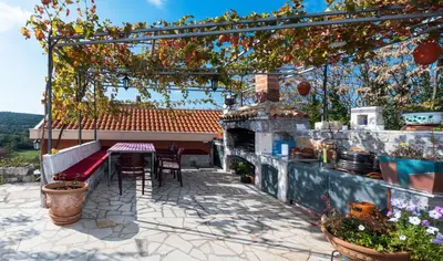 a patio with a table and chairs on a house at Apartmani Kamena Ruža in Budva