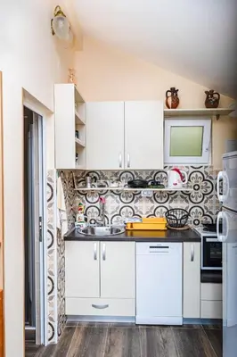 a kitchen with white cabinets and a microwave at Apartmani Kamena Ruža in Budva