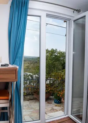 a sliding glass door with a view of a yard at Apartmani Kamena Ruža in Budva