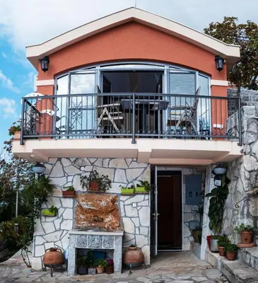 a house with a balcony on top of it at Apartmani Kamena Ruža in Budva