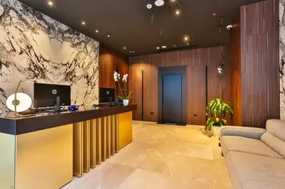 a lobby with a reception desk and a couch at Hotel Kalos in Budva