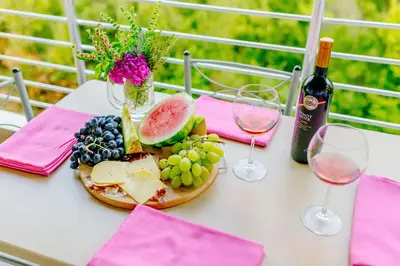 a table with a plate of fruit and wine glasses at Apartments Wild Beauty in Sutomore