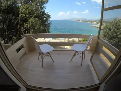 a balcony with two chairs and a view of the ocean at SeaStar Eco Villa in Utjeha
