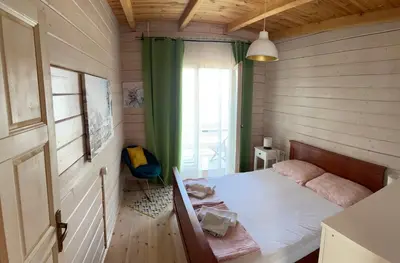 a bedroom with a bed in a wooden room at SeaStar Eco Villa in Utjeha