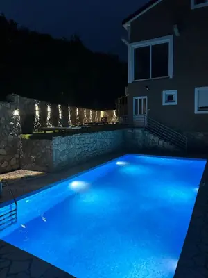 a swimming pool lit up at night at Brioni in Virpazar