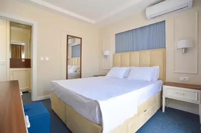 a bedroom with a large bed and a desk at Vistamar Hotel & Apartments in Budva