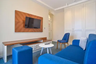 a living room with blue chairs and a flat screen tv at Vistamar Hotel & Apartments in Budva
