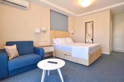 a hotel room with a bed and a blue couch at Vistamar Hotel & Apartments in Budva