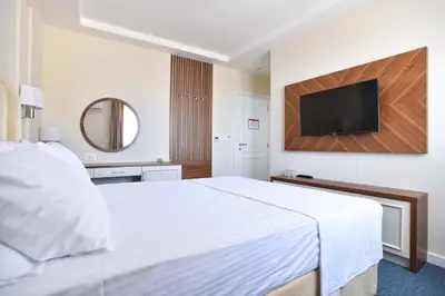 a hotel room with a bed and a flat screen tv at Vistamar Hotel & Apartments in Budva