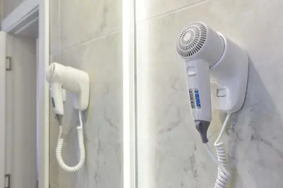a hair dryer and a blow dryer on a wall at Vistamar Hotel & Apartments in Budva