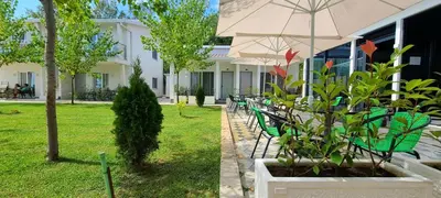 a group of tables and chairs with an umbrella at Casa Al Mare in Ulcinj