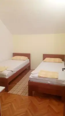 two beds in a room with wooden floors at Vacation home in Virpazar