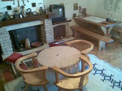 a living room with a table and chairs and a fireplace at Vacation home in Virpazar