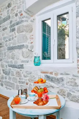 a tray of food on a table in a stone house at La Rocca Apartment Old Town Kotor in Kotor