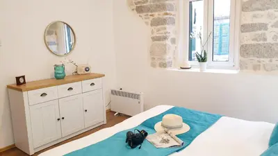 a bedroom with a bed with a hat and a mirror at La Rocca Apartment Old Town Kotor in Kotor