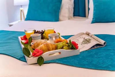 a tray of food on a bed with drinks and fruit at La Rocca Apartment Old Town Kotor in Kotor