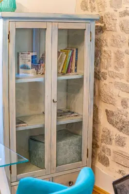 a wooden book shelf with books in it at La Rocca Apartment Old Town Kotor in Kotor