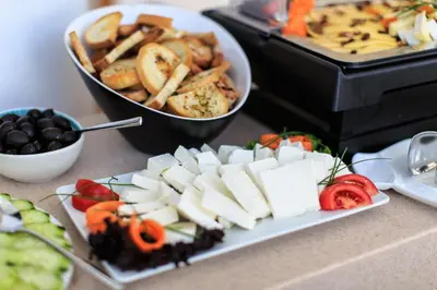 a plate of food with cheese and vegetables on a table at Villa Dvor Kornic in Budva