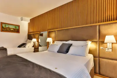 a hotel room with a large bed with white pillows at Villa Dvor Kornic in Budva