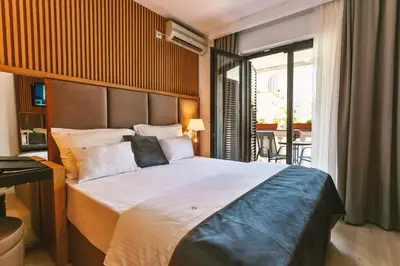 a bedroom with a large bed and a balcony at Villa Dvor Kornic in Budva
