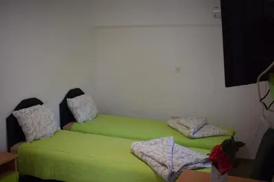 two beds in a room with green sheets at OLD TOWN STUDIOS in Budva