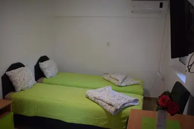 two beds in a room with green sheets at OLD TOWN STUDIOS in Budva
