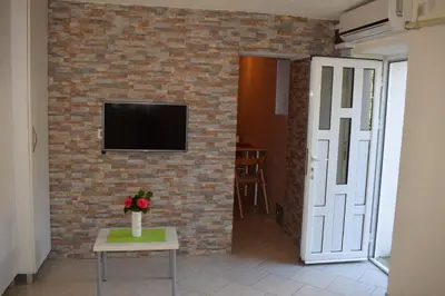 a living room with a brick wall and a tv at OLD TOWN STUDIOS in Budva
