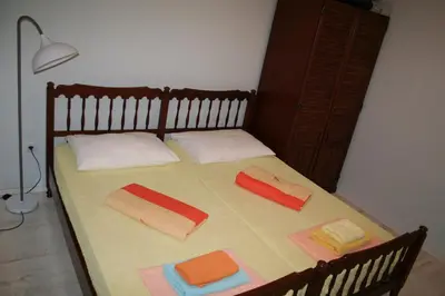 a bed with two pillows and towels on it at Beachfront apartment in Becici,Rafilovici,Budva in Budva