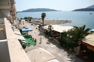 an aerial view of a beach with palm trees and buildings at Beachfront apartment in Becici,Rafilovici,Budva in Budva