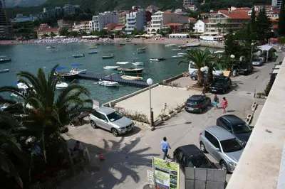 a group of cars parked in a parking lot near a harbor at Beachfront apartment in Becici,Rafilovici,Budva in Budva