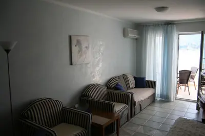 a living room with two chairs and a couch at Beachfront apartment in Becici,Rafilovici,Budva in Budva